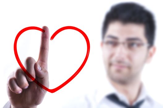 Young business man drawing a heart on a glass board