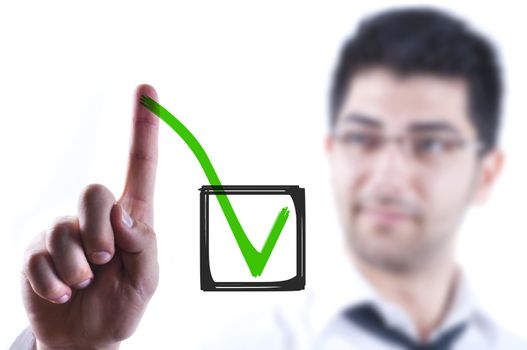 Young business man drawing a tick in a box on a glass board