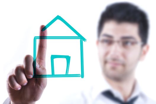 Young business man drawing a house on a glass board