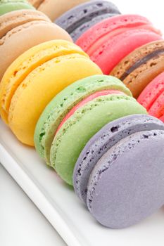 A closeup of some delicious french macaroons sitting on a white plate..  