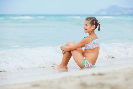 Adorable happy smiling little girl on beach vacation