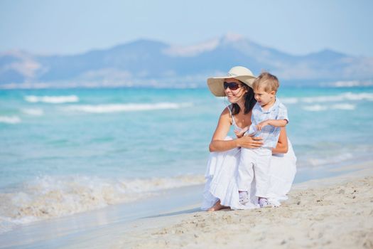 Young mother with her son on tropical beach vacation