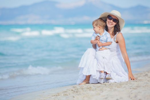 Young mother with her son on tropical beach vacation