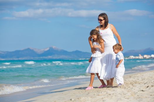 Young mother with her two kids on tropical beach vacation