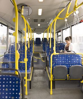 Young woman with a book alone on the bus