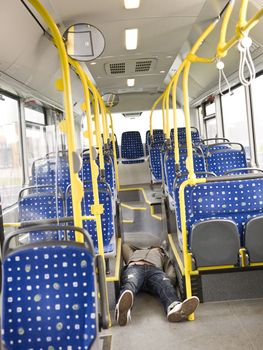 Young man lieing on the floor on the bus