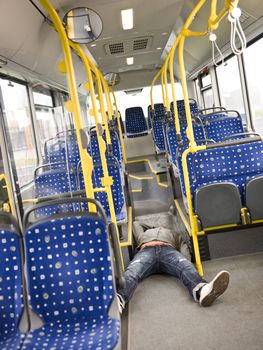 Young man lieing on the floor on the bus