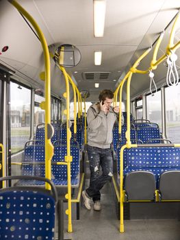 Young man on the phone going by bus