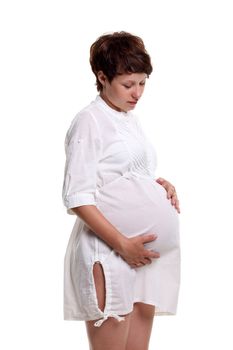 Pregnant young woman in a white shirt on the white background
