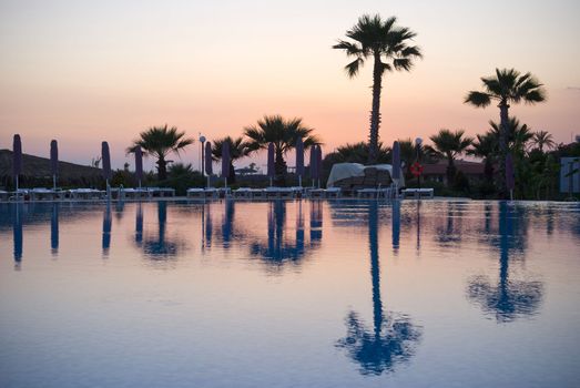 Palms reflection near the swimming pool in turkish hotel