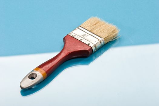 red paint brush on the blue background
