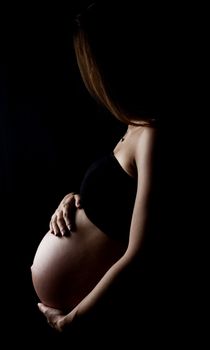 pregnant woman isolated on black background.