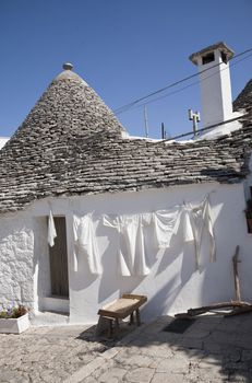Washing day Alberobello, Apulia - Italy. A trullo is a traditional Apulian stone dwelling with a conical roof. The style of construction is specific to Itria Valley.
