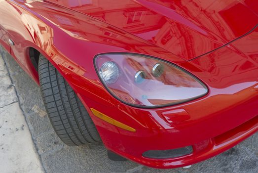 Closeup of well known expensive Italian automobile parked in city.