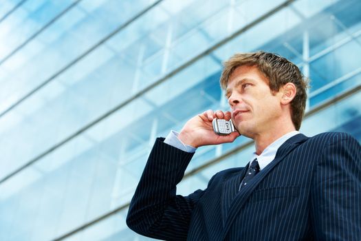 Man outside office building, using cell phone