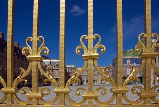 the Palace of Versailles seen through its gilded gates