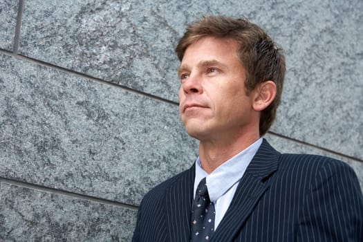 Portrait of man by building wall, looking away