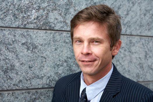 Portrait of man by building wall, smiling