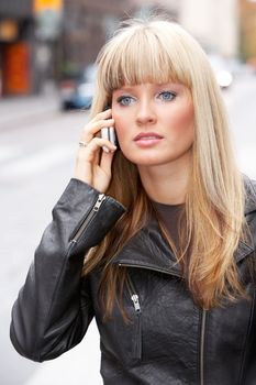 Young woman using mobile phone in street