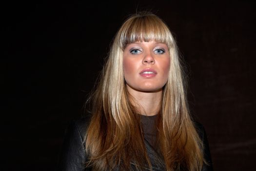 Young woman in dark passageway, looking at camera