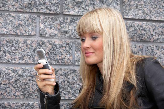 Young woman looking at mobile phone, smiling