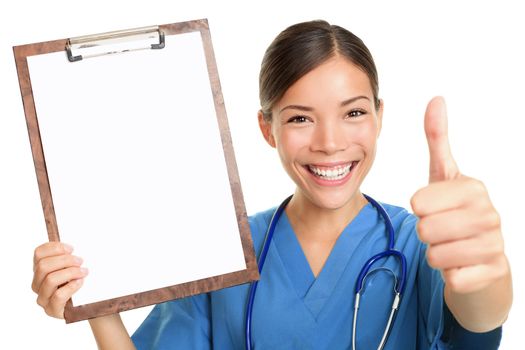 Nurse showing blank clipboard sign smiling happy giving thumbs up success sign wearing stethoscope and scrubs. Multicultural Asian Caucasian female nurse or young doctor isolated on white background.