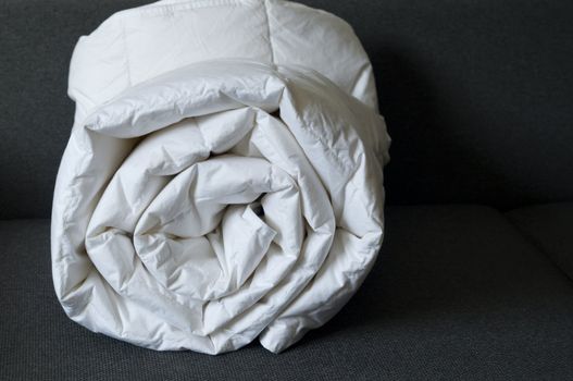 Detail of a rolled white down comforter