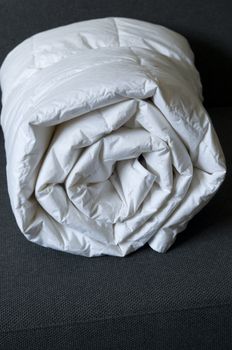Detail of a rolled white down comforter