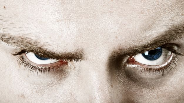 blonde young man with frowning blue eyes close up crop