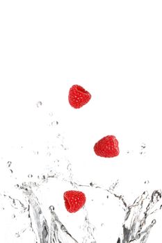 Raspberries splashing in water