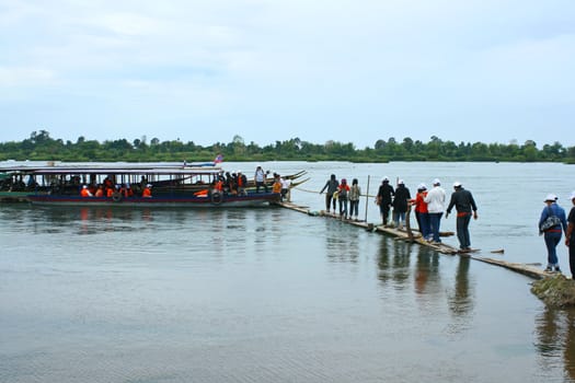 People going to boat on wooden pier