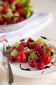 Delicious fruit salad with strawberries, raspberries and grapes