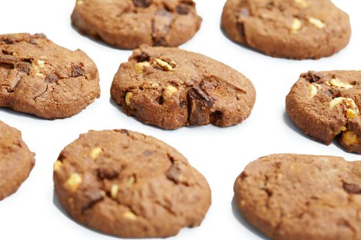 Biscuits with chocolate and nuts on white surface