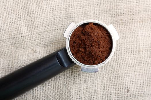 An espresso handle filled with ground coffee