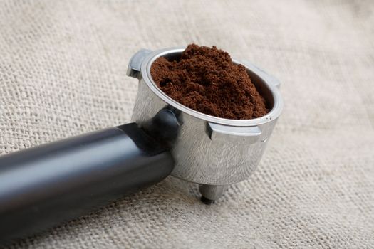 An espresso handle filled with ground coffee