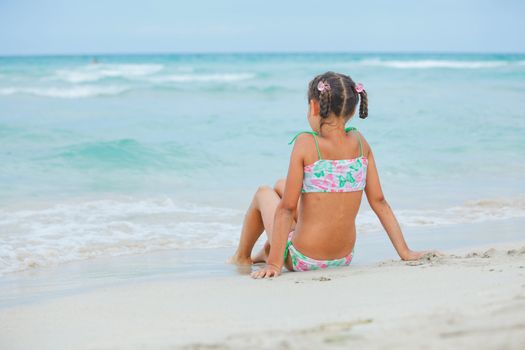 Adorable happy smiling little girl on beach vacation