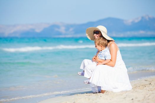 Young mother with her son on tropical beach vacation