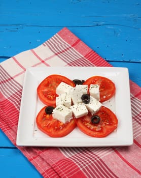 Tomato salad with feta cheese and sliced olives 