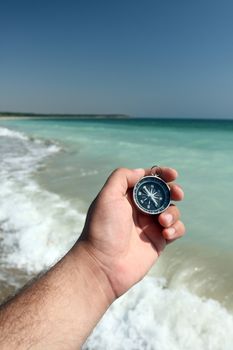 compass in the hand, sea in the background 