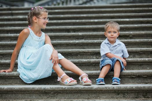 Brother and sister outdoors in city on beautiful summer day