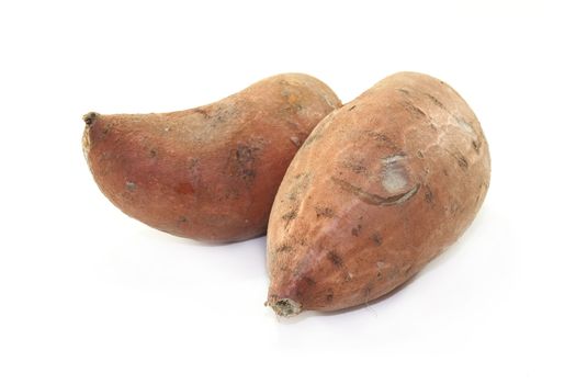 two sweet potatoes on a white background