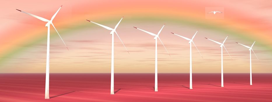 Bird flying over wind turbines with a beautiful rainbow behind