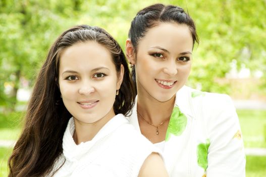 Portrait of two happy young women in a summer garden