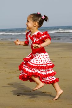 A happy child is running at the beach. Note a bit in motion blur which givs a good speed efect.