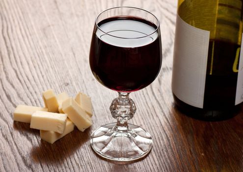 Glass with wine and cheese on a table