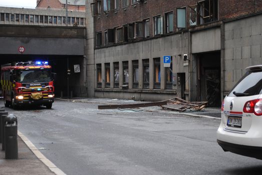 Firetruck and police car in front of damaged building shortly after the terror bomb attack in Oslo 22.07.2011.