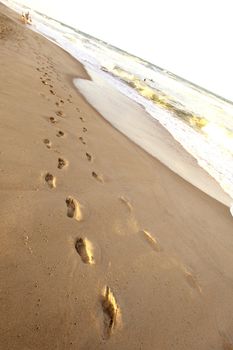 ocean footprints on sand near water