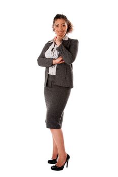 Beautiful self confident curly brunette corporate business woman standing with hand on chin and smiling wearing skirt blouse and black pumps, isolated.