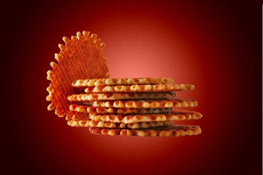 Fresh crisp waffles isolated on dark red background