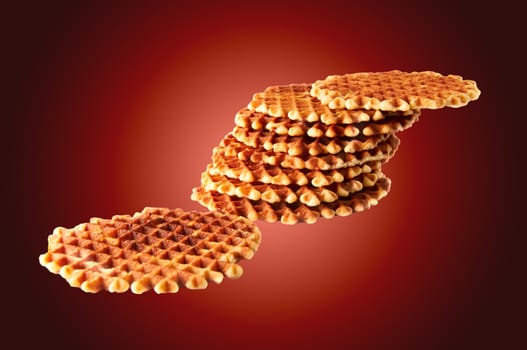 Fresh crisp waffles isolated on dark red background